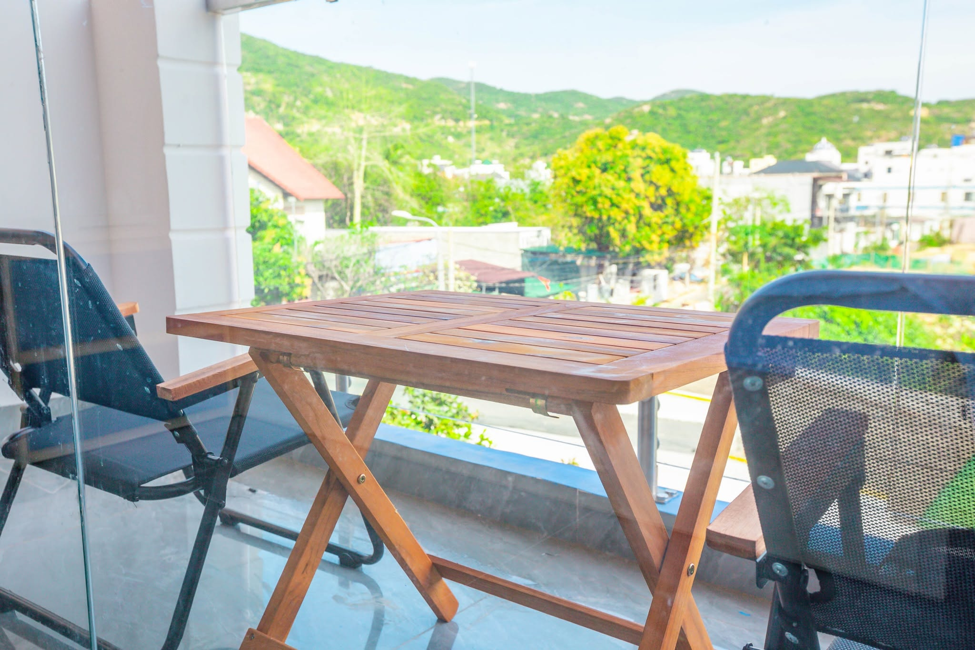 Góc ban công bàn gỗ nhìn ra phố núi