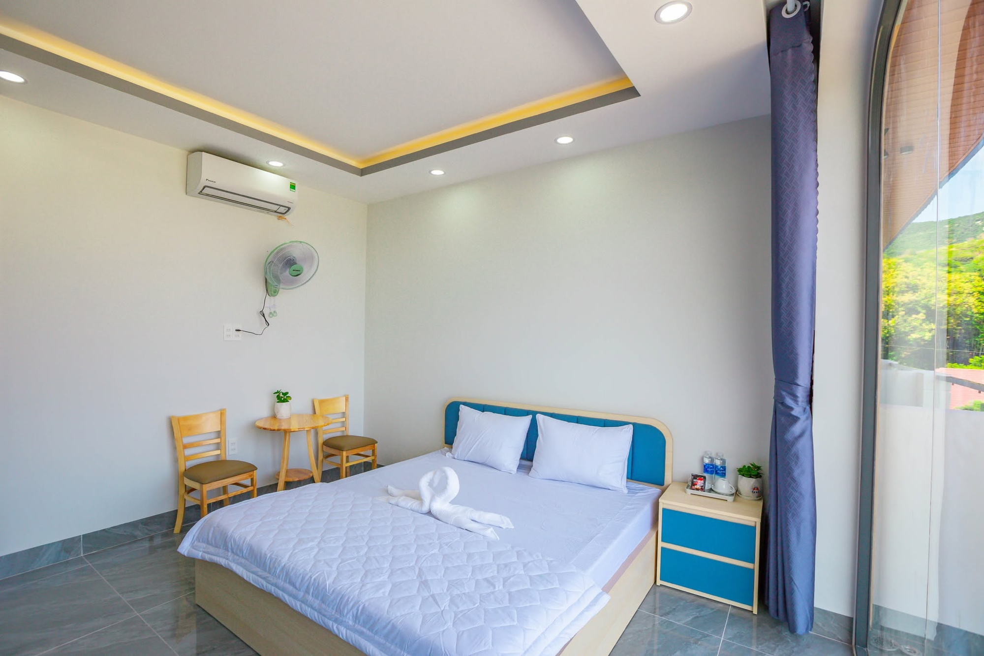Góc phòng đơn, bàn ghế và cửa kính lớn